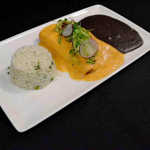 Mr. Sombrero's Mexican enchilada with yellow sauce, rice, and black beans on a white plate.