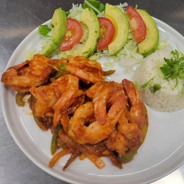 Mr. Sombrero's spicy shrimp dish with rice, avocado, tomatoes, and lettuce on a white plate.
