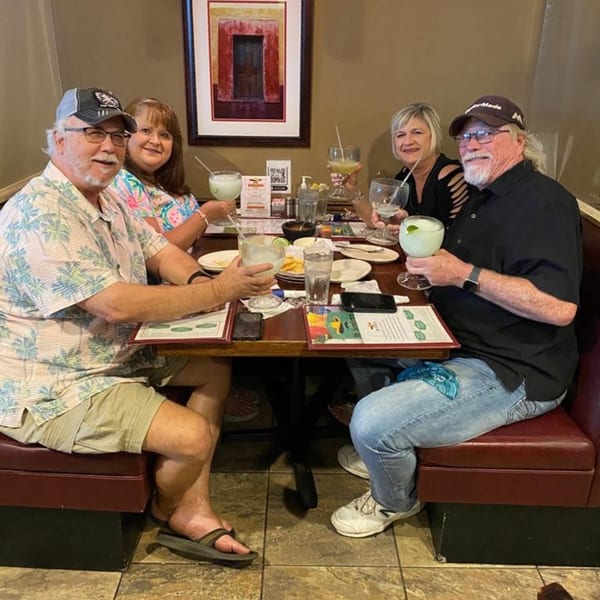Four happy diners enjoying margaritas and food at a table in Mr. Sombrero Mexican restaurant.