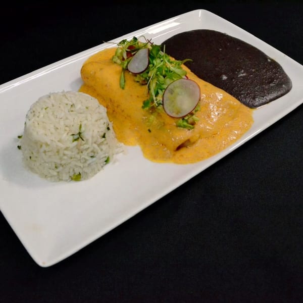 Mr. Sombrero's enchilada with yellow sauce, rice, black beans, and radish garnish on a white plate.